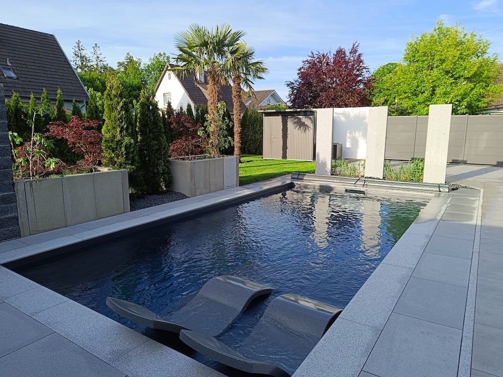 Grüne Gartenanlage mit Pool, Sichtschutz und Blumenhochbeeten