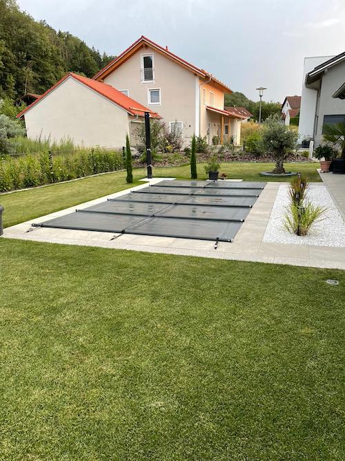 Mit Bodenplatten umrandeter abgedeckter Pool - Pool einwintern