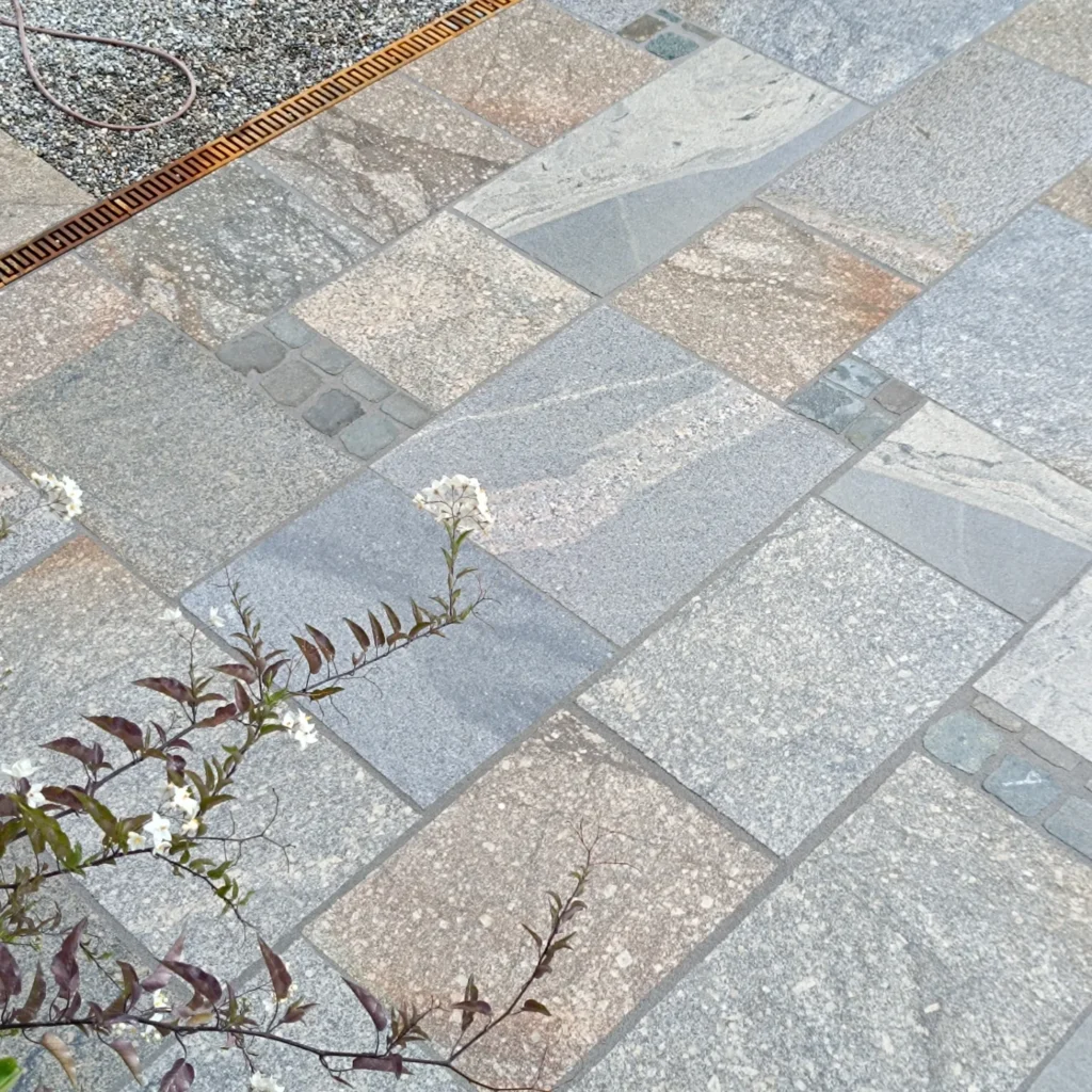 Nahaufnahme einer Einfahrt mit verlegten Natursteinen in einem gleichmäßgem Muster