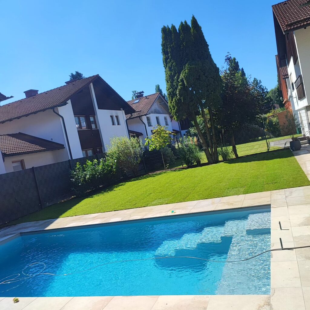 Poollandschaft mit Rollrasen und Pflanzbeete sowie Terrasse